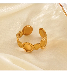 Detailed close-up of golden geometric open ring with circular charms on silk fabric