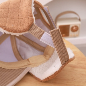 Close-up of winter child hat showing corduroy fabric, warm lamb wool lining and velcro strap