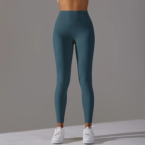 Macro detail of high-waist yoga leggings showing seamless dark teal fabric and texture