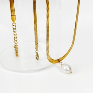 Macro view of gold snake chain necklace with freshwater pearl pendant and lobster clasp