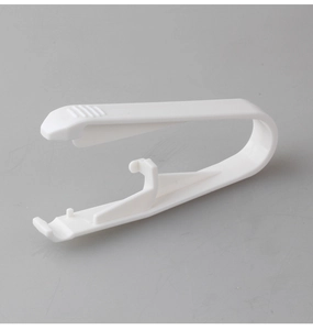 Close-up of white plastic disposable ear piercing gun tool with ergonomic U-shaped grip