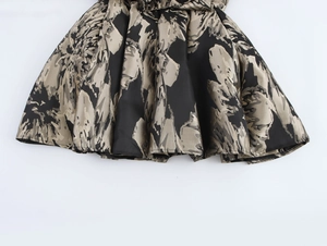 Close-up of elegant gold jacquard pattern on black vintage flared dress fabric