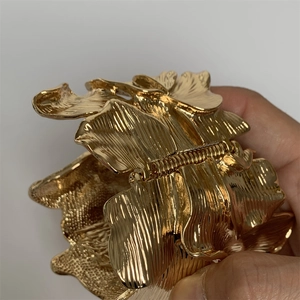 Detailed macro view of gold leaf petal bracelet with brushed metal texture and hinge
