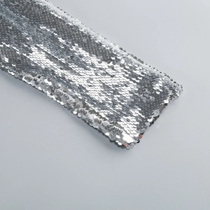 Detailed close-up of high-density silver sequins on elegant backless evening gown