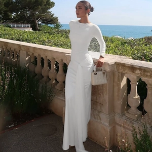 Close-up of white slim-fit maxi dress featuring elegant waist tie and drape detail