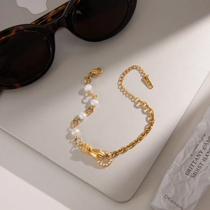 Élégant bracelet main de l'amitié doré avec perles d'eau douce sur un ordinateur portable