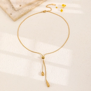 Close-up of golden teardrop pendant Y-necklace with adjustable sliding clasp mechanism