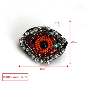Macro detail of the evil eye brooch with colorful beads, crystals, and size dimensions