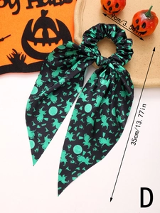 Detail of Halloween hair scrunchie with witch and pumpkin prints and long streamers