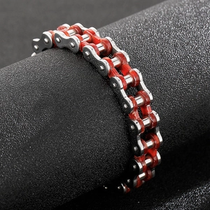 Detail eines rot-silbernen Motorradketten-Armbands aus Edelstahl auf schwarzem Display