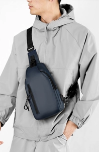Navy blue waterproof sling bag for men featuring integrated USB charging port for devices