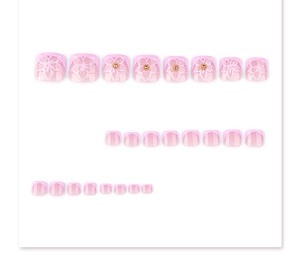 Close-up of pink French press-on toenails with 3D white flower motifs and gold rhinestones