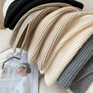 Minimalist thick knit turtleneck scarf poncho in various neutral colors stacked on fleece