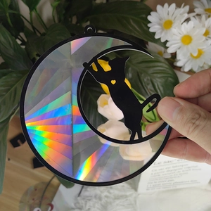 Detail of round suncatcher with black cat and moon silhouette on rainbow prism glass