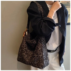 Detail of leopard print tote bag with vintage wooden bead handle charm and matte texture