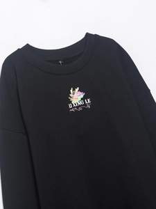 Detalle del estampado de dragón colorido y cuello redondo acanalado en la sudadera