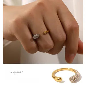 Detailed view of an open gold ring featuring a polished bead and pavé white diamonds