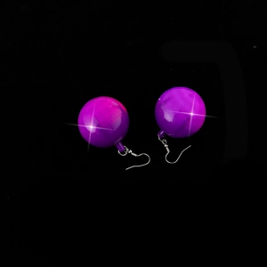 Macro shot of purple disco ball earrings with reflective surface and silver metal hooks