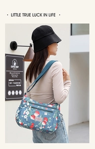 Close-up of strawberry print shoulder bag with multiple zippers for outdoor travel storage