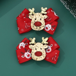 Detail of Christmas reindeer hair clips with red snowflake bows and gold glitter motifs