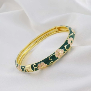 Retro style cloisonne enamel bangle with pink flowers and gold trim on green finish