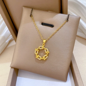 Close-up of gold horseshoe link pendant with cubic zirconia stones in a jewelry box