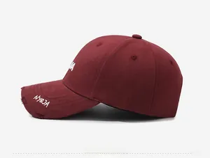Detail of burgundy baseball cap featuring distressed brim and NY&JA side embroidery