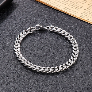 Close-up of a silver Cuban link bracelet with a lobster clasp on a vintage background