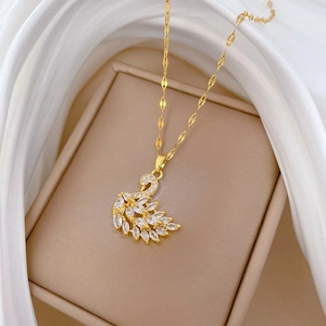 Close-up of a gold swan pendant necklace with sparkling stones on white silk