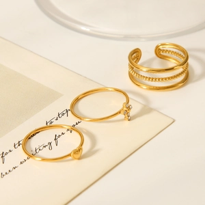 Detailed view of three-piece gold ring set featuring heart and rhinestone accents