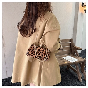 Detail of leopard print crossbody bag with gold chain strap and pearl clasp accent