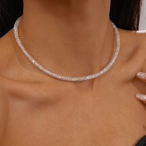 Close-up of a silver mesh choker necklace with sparkling zircons worn by a model