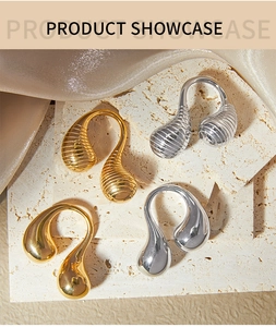 Detailed view of teardrop rings in gold and silver with smooth and textured metallic finishes
