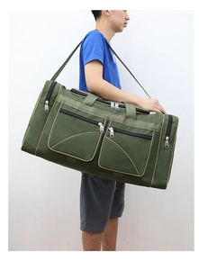 Detail of army green travel bag featuring multiple external zipper pockets and shoulder strap