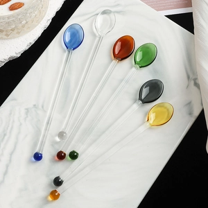 Set of six colorful heart glass stirrers with long handles on marble background