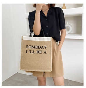 Detail shot of khaki linen tote bag with black slogan print in a minimalist room