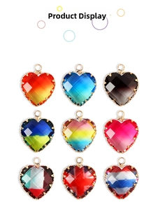 Macro shot of faceted heart-shaped glass charms with golden metal frames and top loops