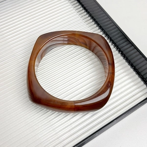 Macro detail of square resin bangle with dark brown tortoiseshell marble pattern