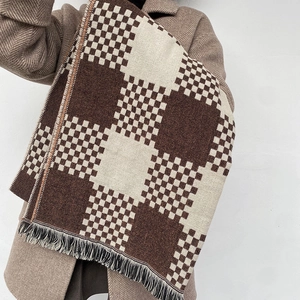 Detail showing the thick brown and beige checkered scarf texture with fringe tassels