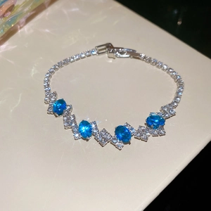 Detailed close-up of luxury silver butterfly bracelet with blue gemstones and diamonds
