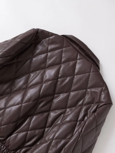 Détail d'une veste en similicuir marron foncé avec surpiqûres matelassées et texture