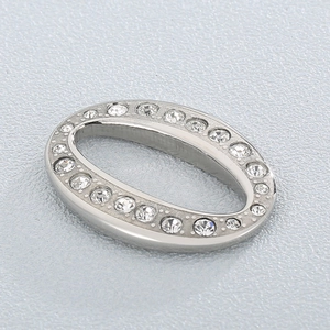 Macro shot of silver oval geometric jewelry connector with sparkling cubic zirconia pavé