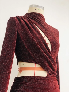 Detail aus dunkelrotem Glitzerstoff mit eleganter Faltenstruktur und Metallfasern