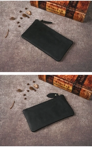 Close-up of minimalist black crazy horse leather clutch bag with high-quality zipper detail