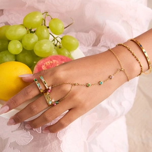 Detailed view of a gold-plated finger bracelet set with colorful zircons on a hand