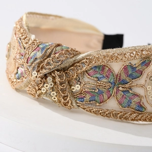 Elegant knotted lace headband with golden embroidery and sequins for a high top style