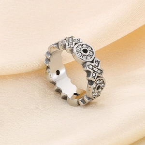 Macro shot of vintage stainless steel ring with XO patterns and crystal accents