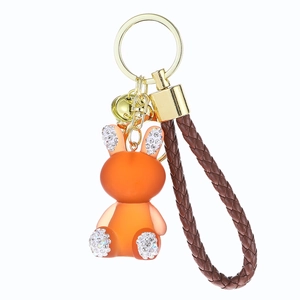 Orange resin jelly rabbit keychain with sparkling rhinestones and brown braided leather strap