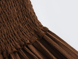 Detail of brown smocked fabric texture with ruffled edges for beach resort skirt set