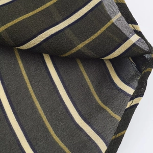 Close-up of lightweight dark green and beige striped fabric texture with fine weave details